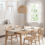 Scandinavian dining room with natural wood table and woven lamp.